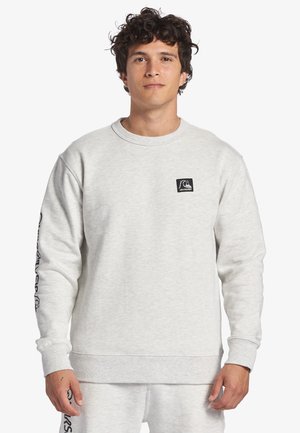 Light gray sweatshirt in cotton blend. Features a round neckline, ribbed cuffs, and logo patch on the chest. Soft texture with long sleeves.