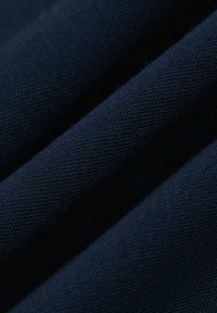Granatowy, teksturowany materiał z plecionym wzorem, ukazujący fałdy i głębię, z gładką powierzchnią i widocznymi włóknami.