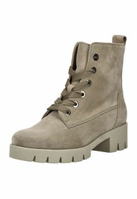 Beige suède enkellaars met ronde neus, zes veterogen, en dikke blokhak. Gelaagde bovenkant met stiksel detail en rubberen zool.