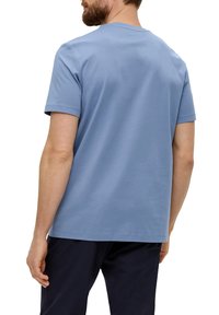 Helles blaues T-Shirt mit kurzen Ärmeln aus Baumwolle, mit klassischem Rundhalsausschnitt und entspannter Passform, mit glatter Textur und minimalen Details.