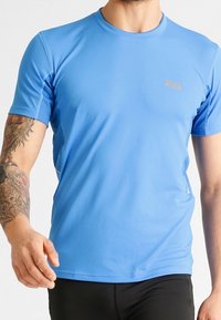 Blå kortärmad sporttröja med en slät textur och andningsbara meshsidopaneler; har en diskret logotyp i guld på bröstet.