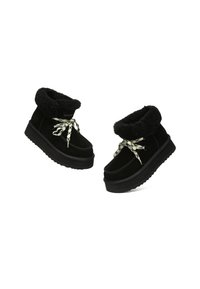 Black fur-lined ankle boots with thick soles and white and black patterned laces, presented on a white background.