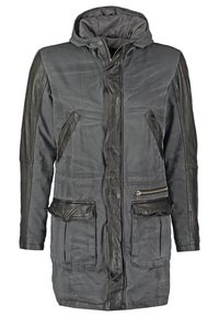 Grå parkajacka med huva, med läderaccenter, framdragkedja, två fickor med lock och kontrasterande texturdetaljer.