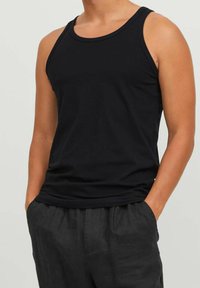 Black tank top made of soft fabric, featuring a sleeveless design, rounded neckline, and a fitted silhouette with no visible patterns.