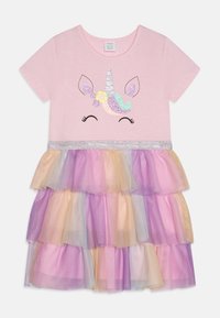 Abito t-shirt rosa con una grafica di unicorno e accenti glitterati. Presenta una gonna in tulle a strati di colori pastello in viola, rosa e giallo.