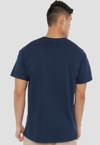 Kurzärmeliges, marineblaues Baumwoll-T-Shirt mit Rundhalsausschnitt, locker geschnitten und ohne sichtbare Muster oder Grafiken auf der Rückseite.
