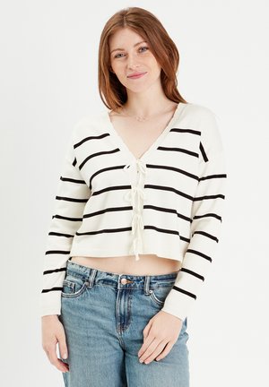 Maglione bianco cropped con strisce orizzontali nere, scollo a V e chiusura a fiocco frontale. Presenta maniche lunghe e orlo a coste.