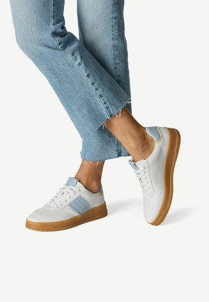 Baskets blanches avec des accents bleu clair et une semelle gomme, présentant un design classique, une tige en cuir texturé, et une fermeture à lacets.