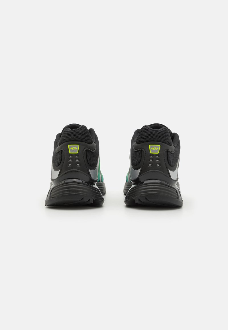 Zapatillas deportivas negras y verdes con una parte superior de malla, suela acolchada y detalles reflectantes. Presentan un logo brillante en el talón.