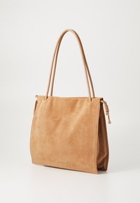 Ruda suede rankinė su dviem ilgu rankenomis, minkštu paviršiumi, stačiakampiu pavidalu ir minimalistišku dizainu. Pabrėžia mažą metalinį akcentą.