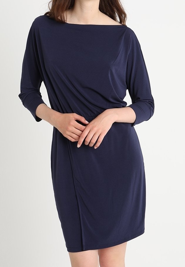 Námořnické modré šaty vyrobené z měkkého, elastického materiálu. Mají široký lodní výstřih, tříčtvrteční rukávy a nabírané detaily v pase.