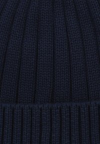 Granatowa, prążkowana czapka dzianinowa o miękkiej fakturze, z pionowymi liniami i złożonym mankietem na dole. Grube włókno nadaje jej przytulny wygląd.