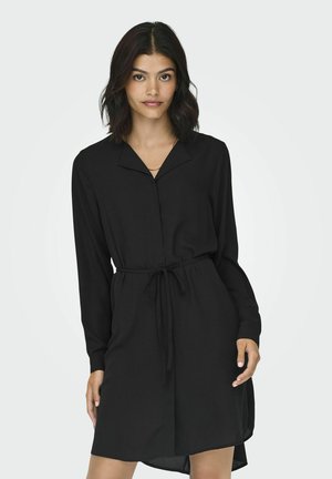 Abito lungo nero a maniche lunghe con collo a camicia, vita regolabile con cintura e orlo leggermente curvo. Realizzato in tessuto liscio e leggero.