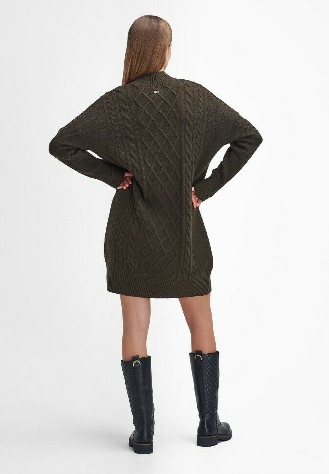Tumma vihreä neulottu mekko, jossa on kaapelitekniikkaa, pitkät hihat, löysä istuvuus ja ribattu helma. Yhdistetty mustiin toppavuoriin ulottuviin saappaisiin.
