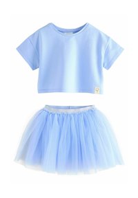 Maglietta cropped azzurra con maniche corte abbinata a una gonna in tulle a strati dello stesso azzurro, dotata di vita elastica.