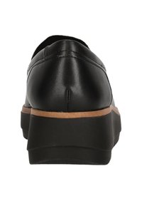 Chaussure en cuir noire avec un bout rond, accent de semelle marron et semelle extérieure en caoutchouc texturé. Des détails de couture sont visibles le long de l'arrière.