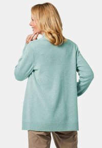 Mintgrüner Cardigan mit langen Ärmeln, geripptem Saum und Bündchen, aus einem weichen Material gefertigt. Bequemer, lässiger Schnitt und mit aufgesetzten Taschen.