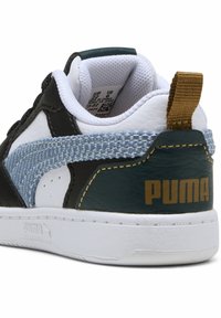 Sneaker noir, blanc et teal avec une bande bleue texturée, un col rembourré, un logo doré "PUMA" et une languette marron à l'arrière.