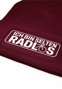 Maroon knit beanie with a textured pattern, featuring a white stitched patch that includes the text “ICH BIN SELTEN RADLOS.”