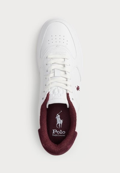 Balti sporta apavi ar perforētu detalizāciju, ādas augšdaļu, bordo zamša apkakli un logotipu, kas izdrukāts zolē. Piestiprināms dizains.