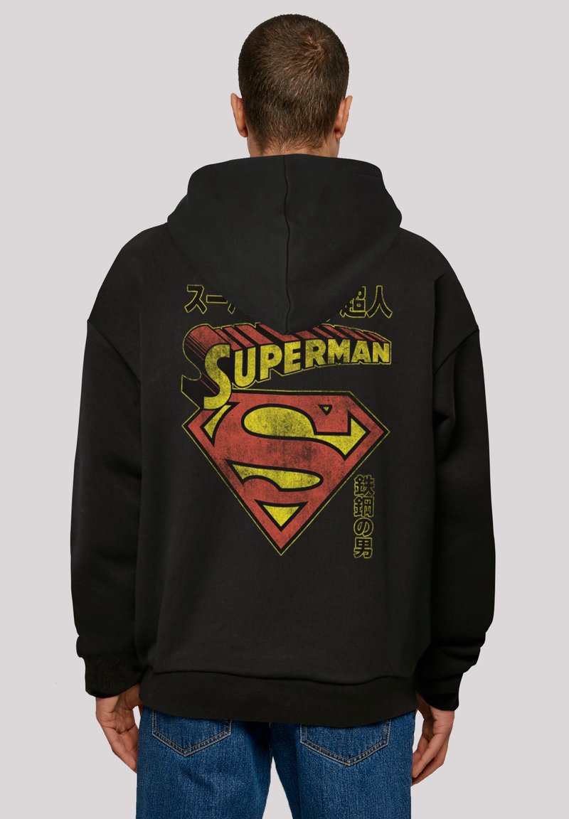 Black hoodie featuring a vintage Superman logo in red and yellow on the back, with Japanese text. Soft fabric, relaxed fit.