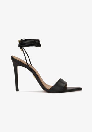 Černé kožené sandály na vysokém podpatku s elegantním designem, otevřenou špičkou, řemínkem kolem kotníku s uvázanými detaily a špičatou špičkou.