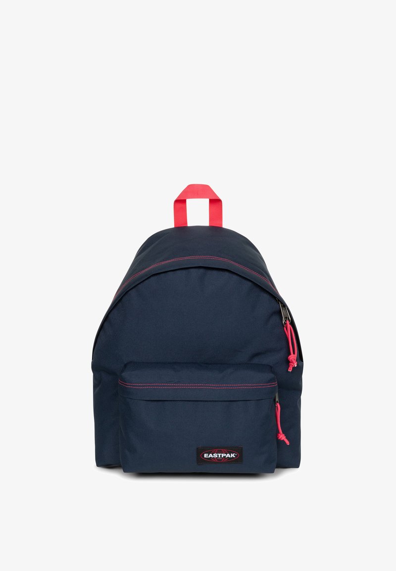 Sac à dos en tissu bleu marine avec une forme arrondie, des accents de fermeture éclair rouges, une poche avant et une poignée supérieure pour le transport. Comprend un patch avec logo.