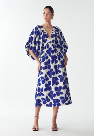 Maxi šaty z ľahkého materiálu s hlbokým výstrihom do V, oversized rukávmi a modrým kvetinovým vzorom na smotanovom pozadí. Majú elastický pás.