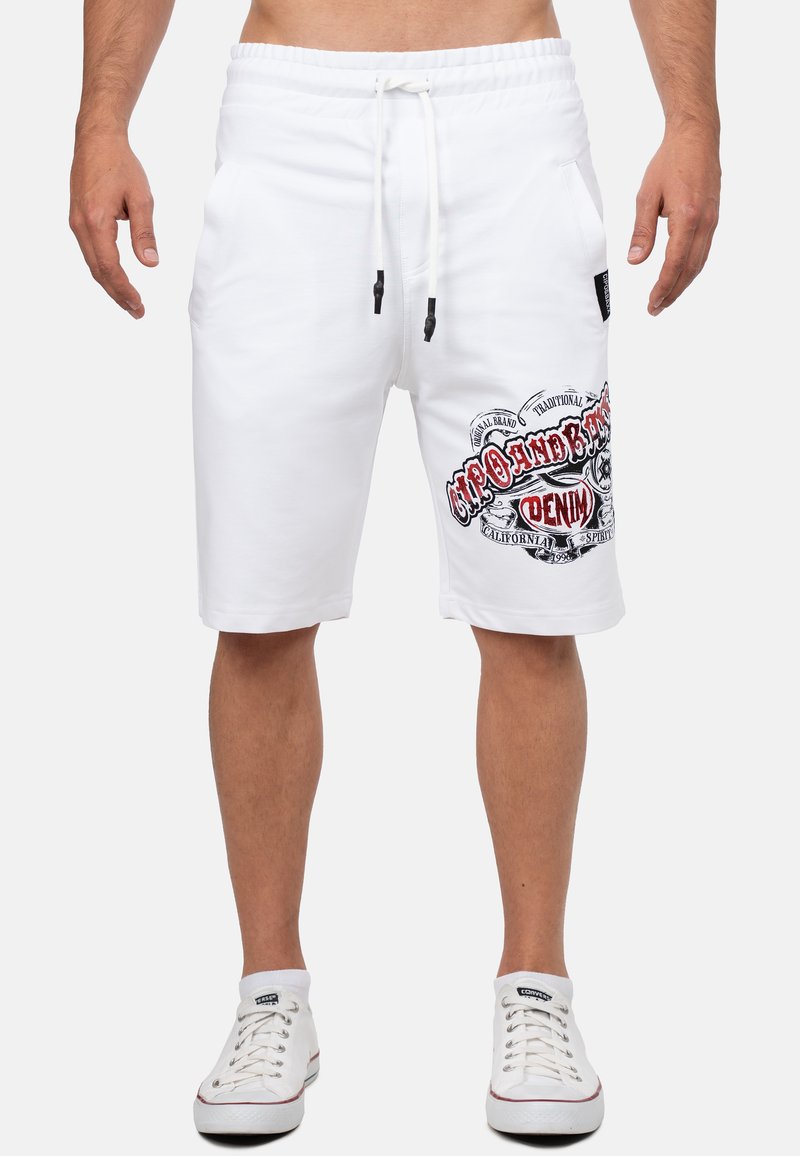 Witte katoenen shorts met een elastische tailleband, voorzien van zijzakken en een grafische print in zwart en rood op de linkerdij.