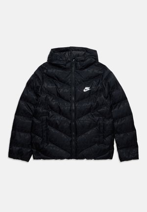 Zwarte gewatteerde Nike-jas met capuchon, rits aan de voorkant en zijzakken, met een subtiel herhalend logo patroon en een witte Nike-swoosh op de borst.