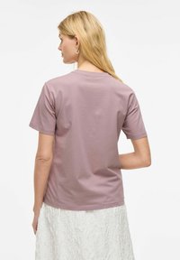 Korte mouw t-shirt in licht mauve katoen, met een ronde halslijn en een ontspannen pasvorm, met een gladde textuur en minimale details.