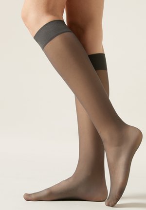Gennemsigtige mørkegrå knæstrømper med en solid sort bånd øverst. Den glatte tekstur fremhæver benets form.