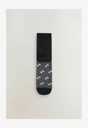 Melnas un pelēkas zeķes ar bišu rakstu pelēkajā daļā, ar gludu tekstūru un kontrastējošu viendabīgu melnu augšdaļu.