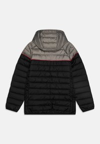Chaqueta acolchada con una sección superior gris y una inferior negra, con capucha, acolchado horizontal y una línea de acento roja a lo largo de los hombros.