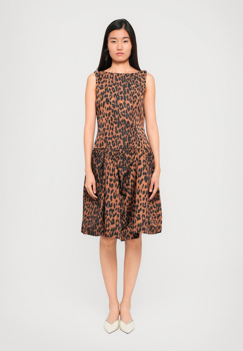 Haljina bez rukava s uzorkom divlje mačke, s uskim gornjim dijelom i raširenom suknjom. Ima oblik broda i suptilno nabrane detalje u struku.