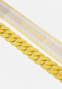 Gul resin kedjebälte med släta länkar, i kombination med ett tygband med beige och gula ränder, och texten "VALENTINO."