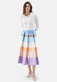 Pleated, multi-colored skirt featuring horizontal stripes in blue, orange, lavender, and cream. Paired with a white button-up blouse.