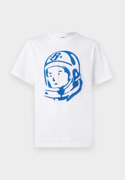 Λευκό βαμβακερό t-shirt με μπλε γραφικό αστροναύτη στο μπροστινό μέρος. Κοντά μανίκια, στρογγυλή λαιμόκοψη και χαλαρή εφαρμογή.