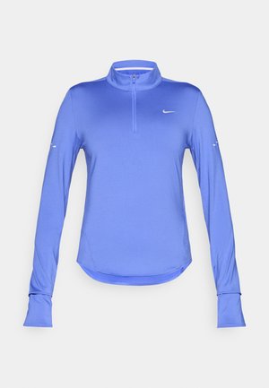 Haut de sport bleu à manches longues avec un col montant, une fermeture éclair quart de devant et des passages pour les pouces. Tissu lisse et extensible avec un petit logo sur la poitrine.