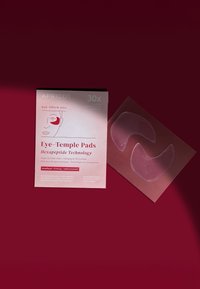 Indpakning af abrikosøje-templepuder, rosa med hvid tekst, inkluderer to klare silikonegelpuder formet til brug omkring øjnene, mærket genanvendelige og genopfyldelige.