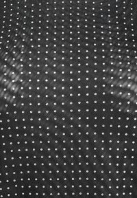 Musta kangas, jossa on sileä pinta ja tasaiseen väliin aseteltuja pieniä hopeansävyisiä niittejä. Nuo niitit luovat hienovaraista kimallusta tumman taustan ansiosta.