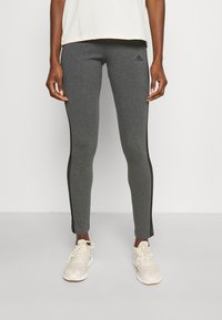 Träningsleggings i mörkgrått med svarta sidostripes. Tillverkade av stretchigt material, med en figurnära design och ett elastiskt midjeband.
