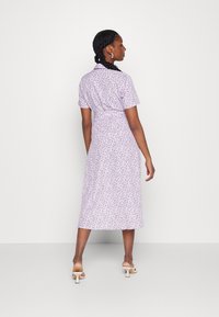 Vestido roxo de flores com mangas curtas, cintura ajustada e comprimento midi. Tecido suave, padrões discretos e detalhe de gola clássica.