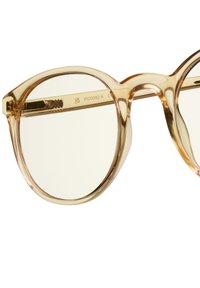 Runda glasögon med genomskinliga ljusbeige acetatbågar och subtil textur på stängerna, med klara linser och utan synliga logotyper.