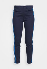 Mörkblå jeans med avsmalnande passform, med blå och vita sidonstripes, framfickor och standard knappstängning.