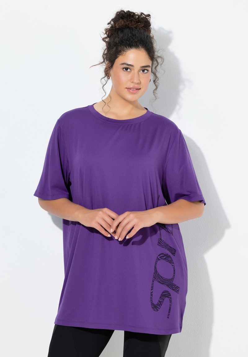 Fioletowy, oversize'owy t-shirt wykonany z gładkiej tkaniny, z okrągłym dekoltem, krótkimi rękawami oraz czarnym nadrukiem w zebra na boku.