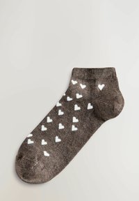 Calzino alla caviglia marrone realizzato in tessuto morbido, con un motivo ripetuto di piccoli cuori bianchi sulla superficie.
