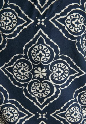 Tumši zils audums ar baltām simetriskām ziedu un ģeometriskām rakstu zīmēm, veidojot romba formas un centrālas ziedu motīvus.