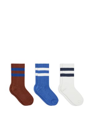 Three pairs of ribbed crew socks in brown with blue stripes, blue with white stripes, and white with black stripes, laid flat side by side.