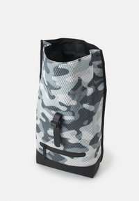 Zaino in rete con un motivo in grigio e nero camouflage, dotato di una base nera solida, chiusura superiore e tasca frontale con zip.